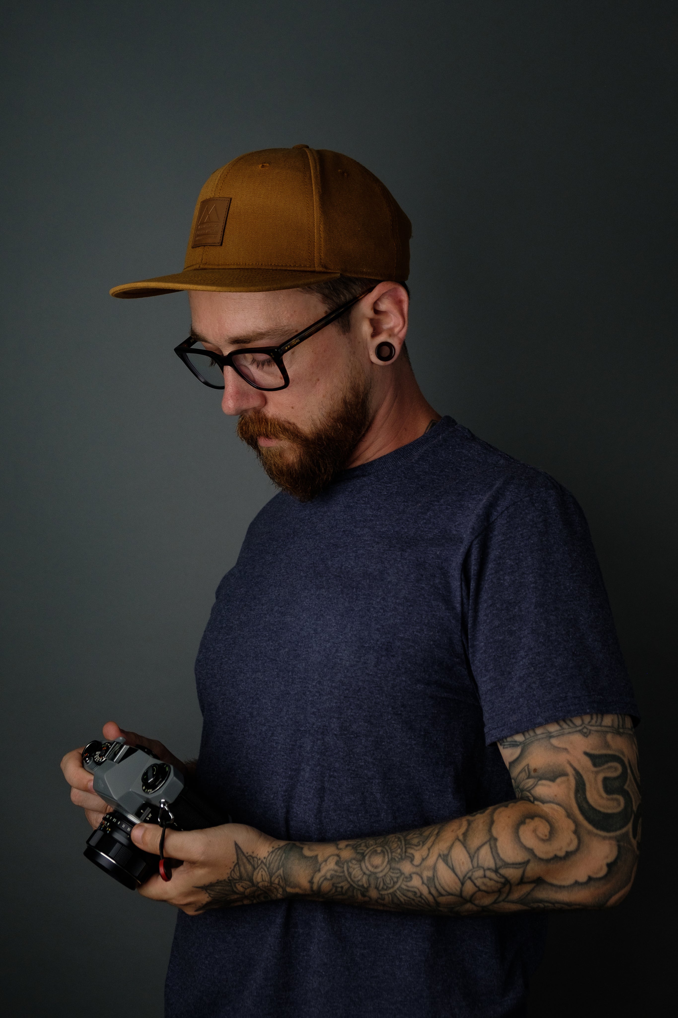 files/tattooed-man-holding-film-camera.jpg